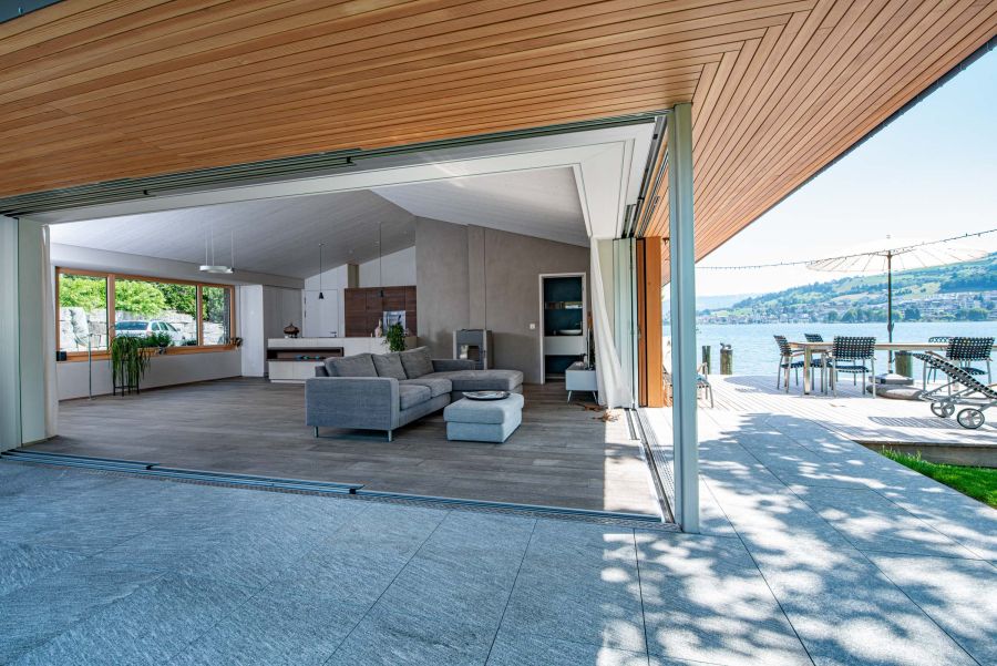 Grossflächige Fensterfronten verbinden den Aussenbereich nahtlos mit mit dem Wohn- und Küchenbereich.